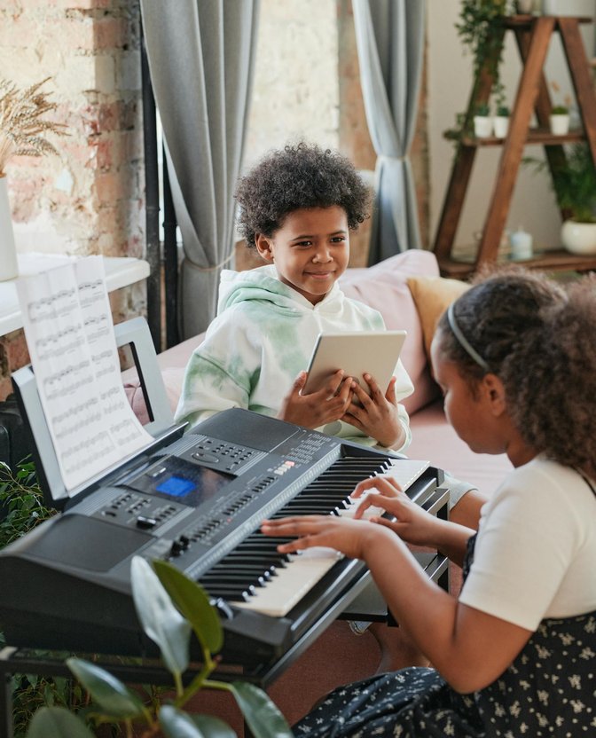 Child playing keyboard during an online piano lesson